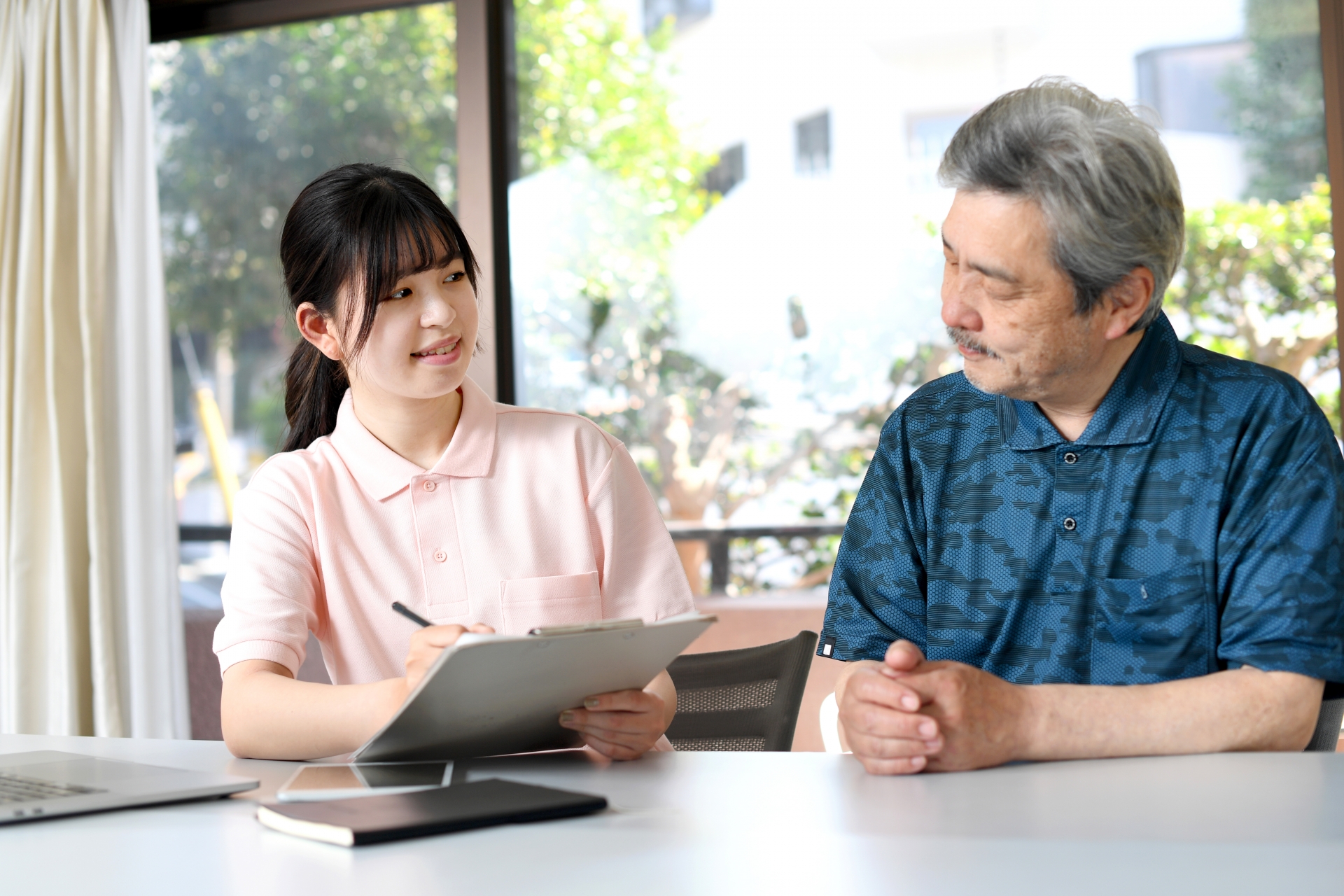 高齢者と会話する女性スタッフ