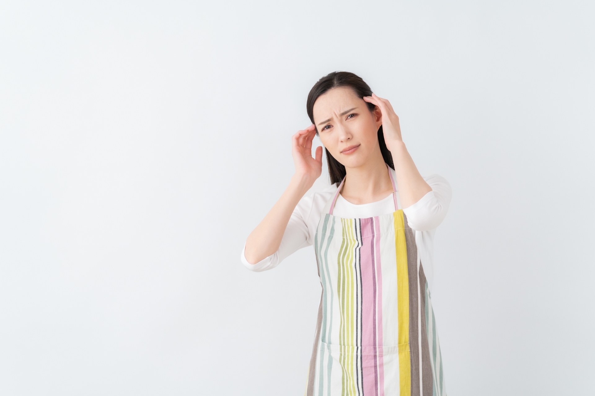 頭に手を当てる女性