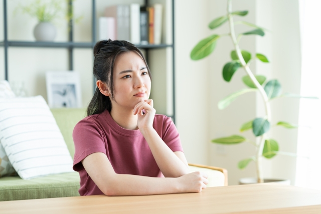 リビングで悩む女性