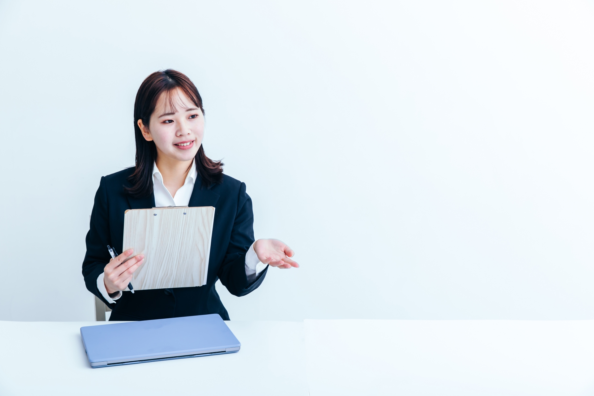 説明をするリクルートスーツの女性