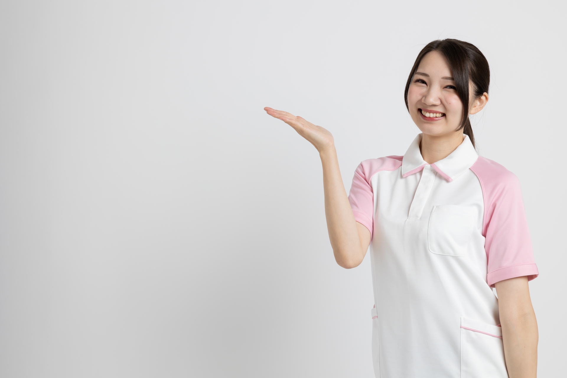 手を上げて案内をする介護士