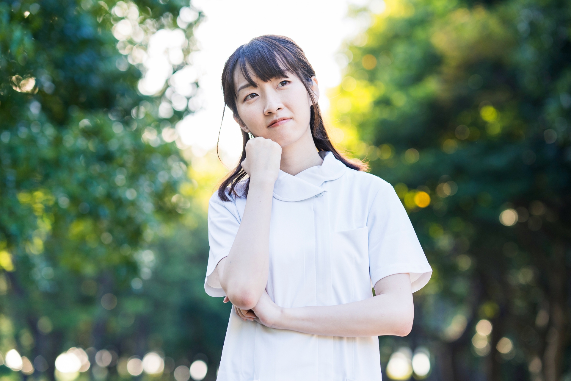 頬に手を当て考える女性