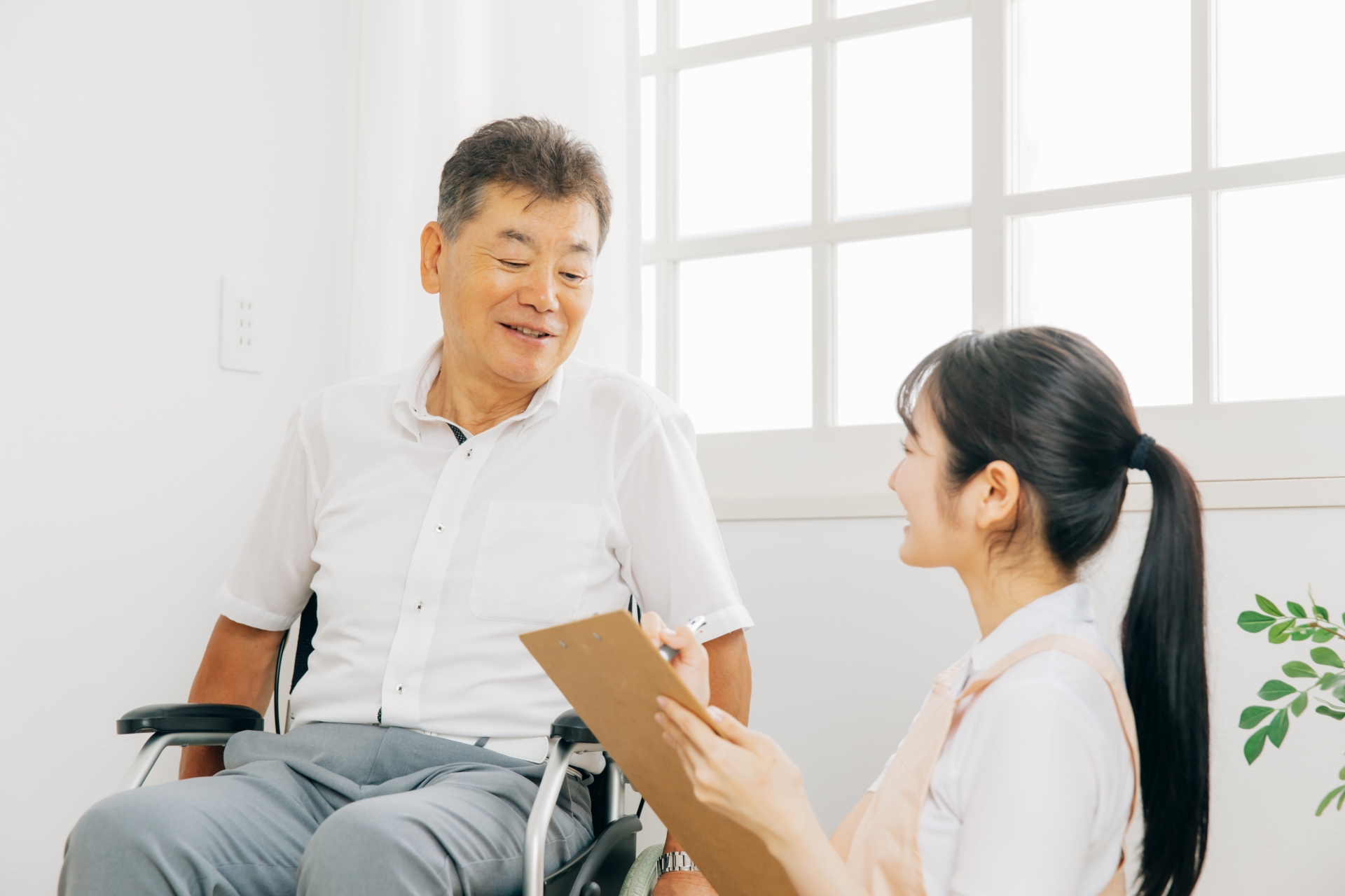 車椅子の男性から話を聞く女性