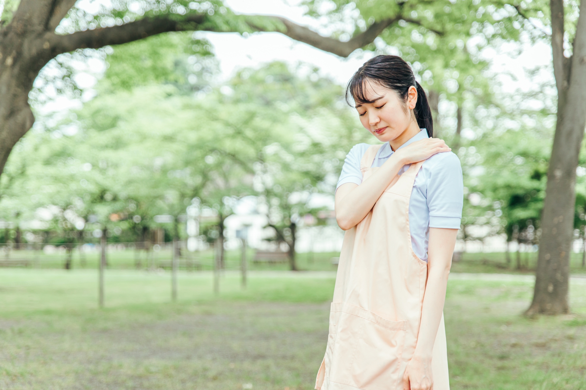 肩を抑える女性