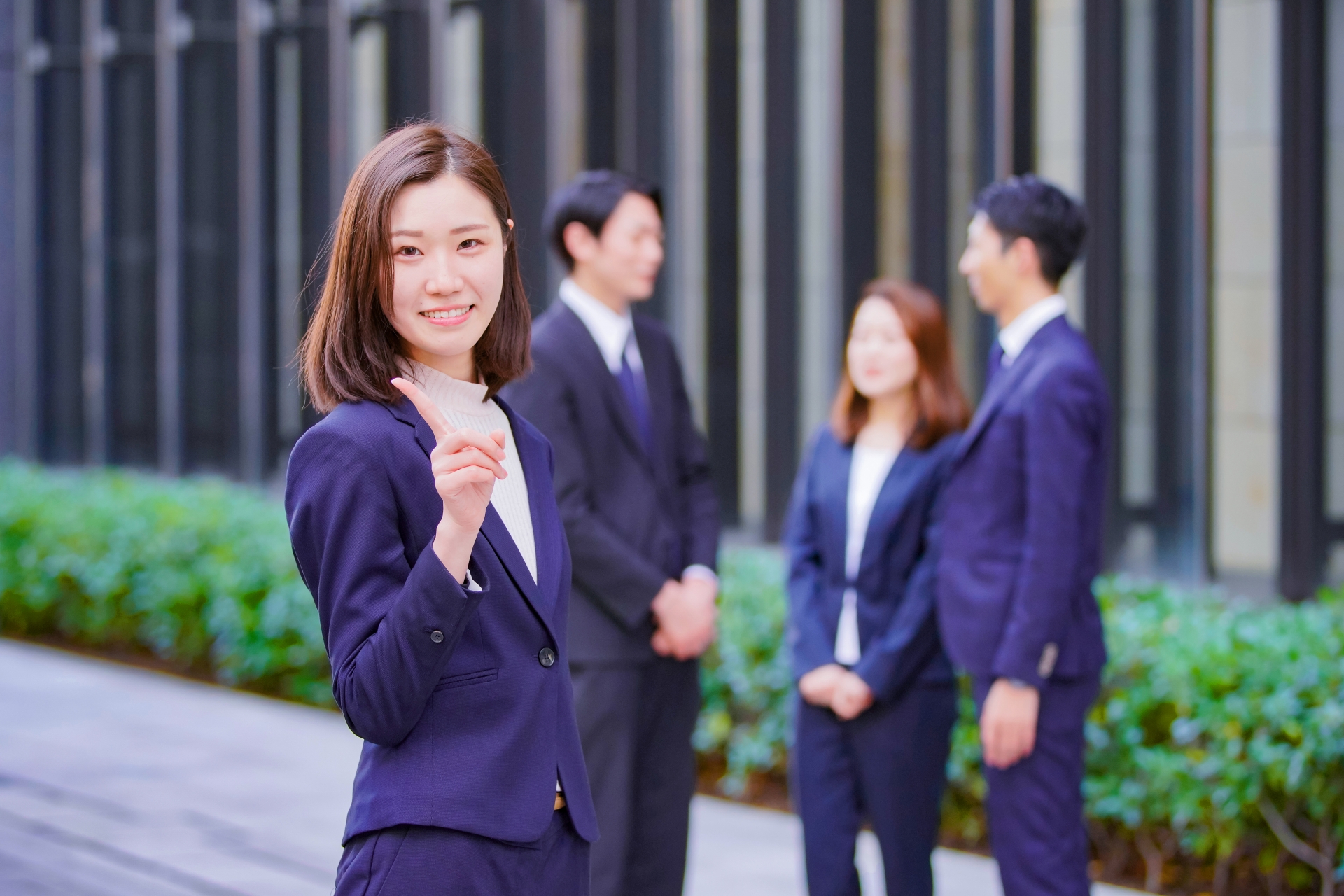 人差し指を出すスーツの女性