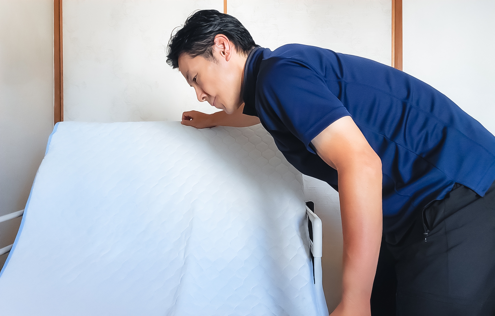 介護ベッドを整える男性