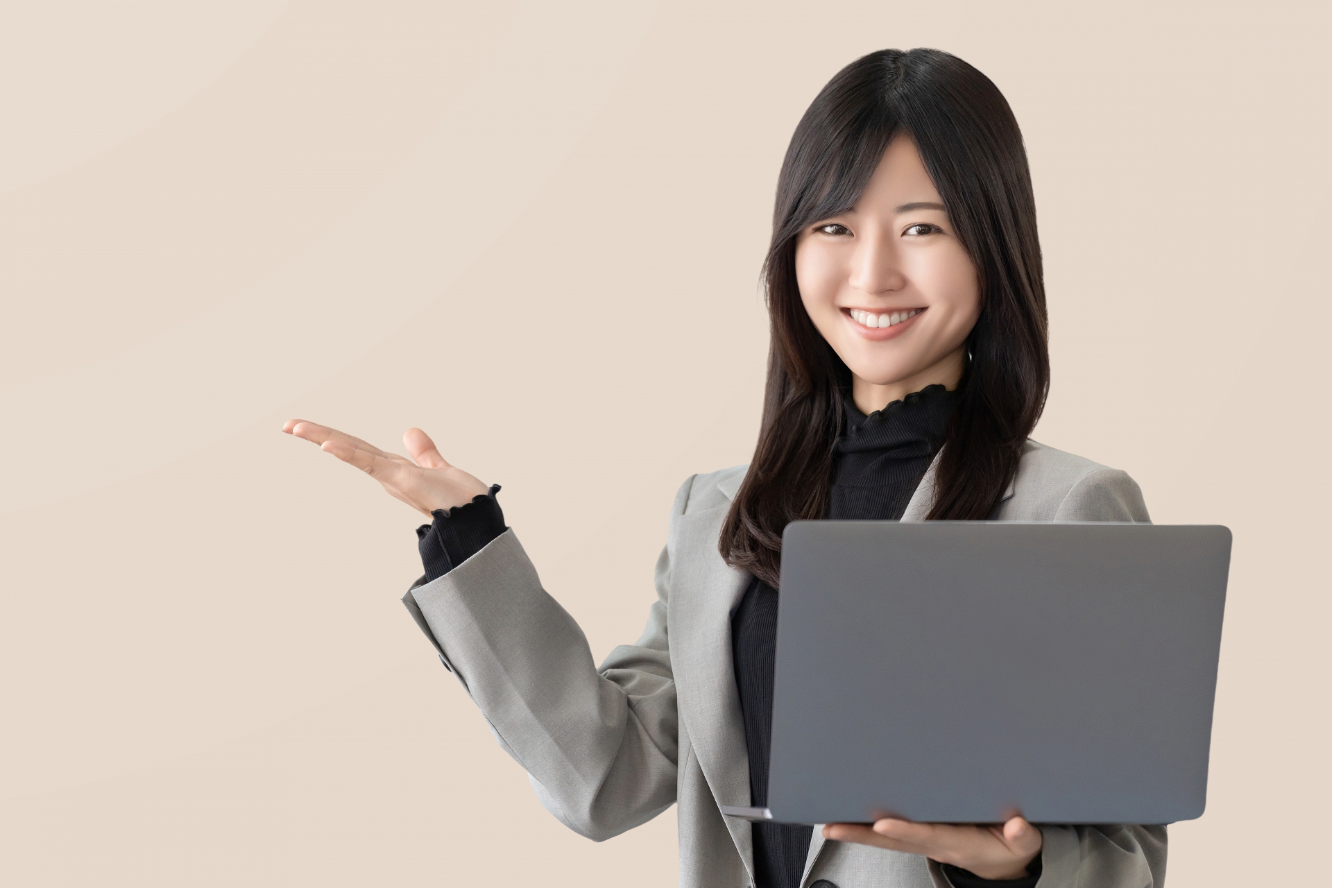 パソコンを持って案内をする笑顔の女性