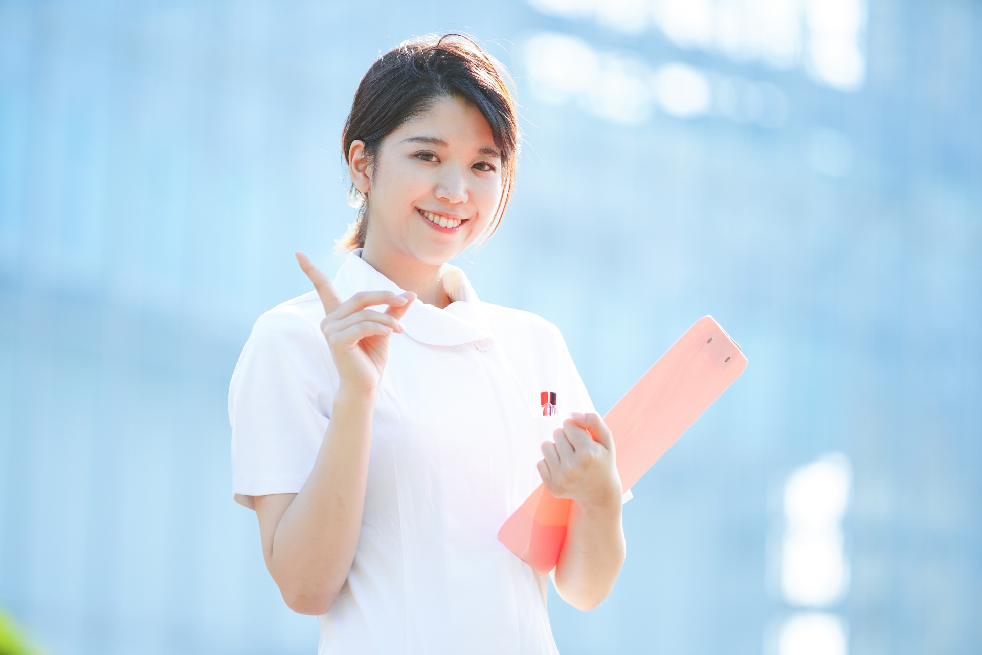 人差し指を立てる白衣の女性