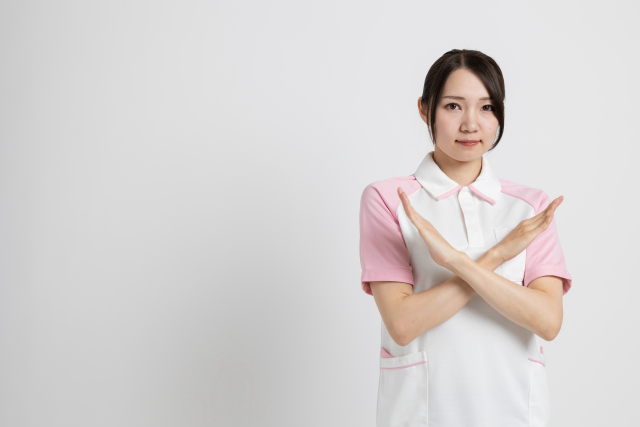 腕でバツをする女性