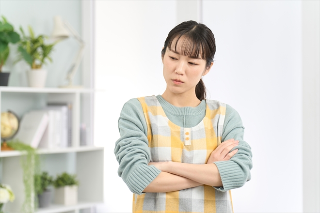 腕を組んで悩む女性