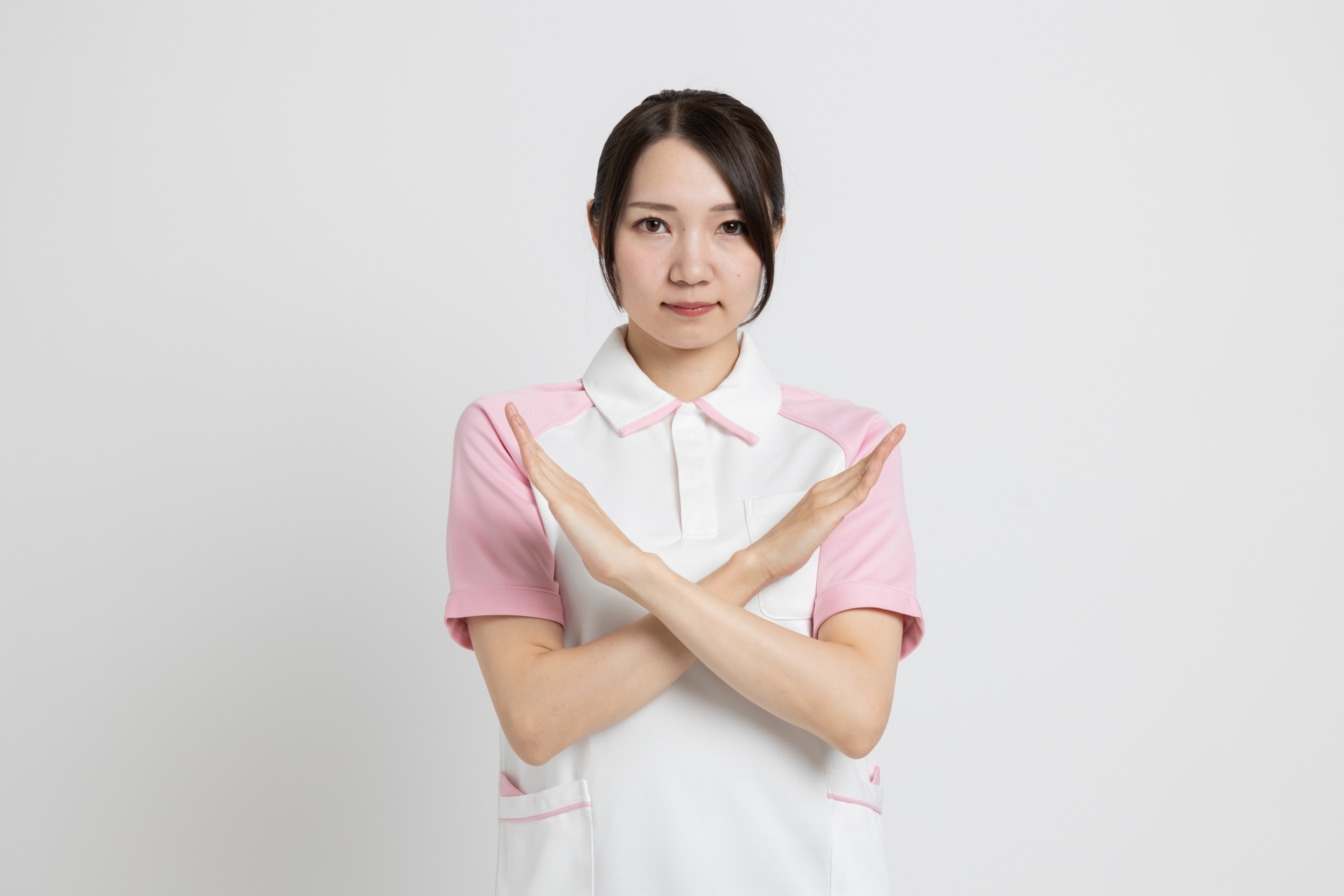 手でバツをする女性