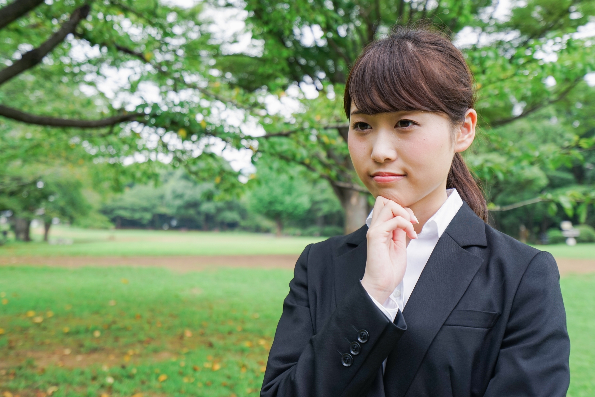 顎に手を当て悩む女性