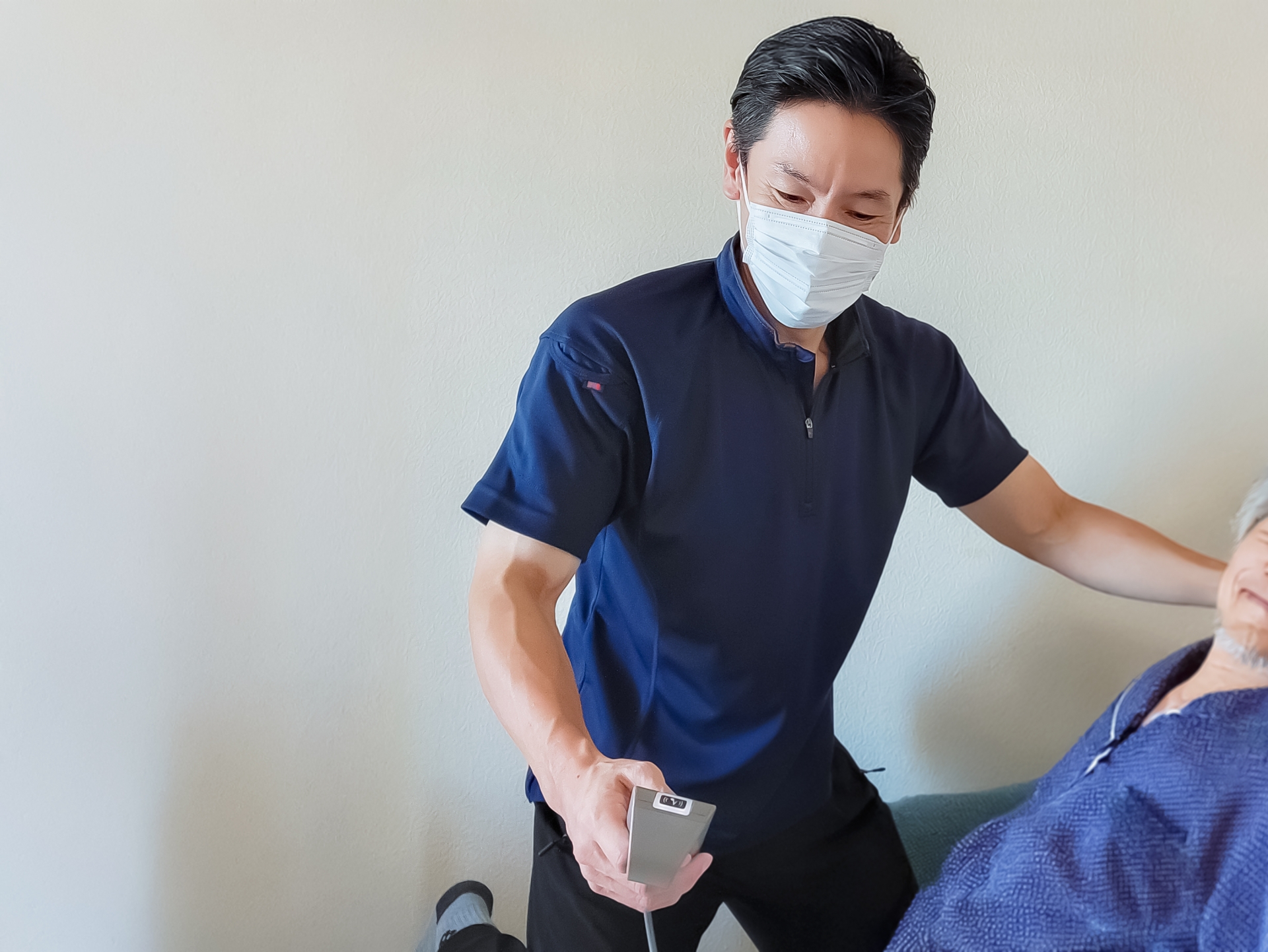 電動式介護ベットを操作する訪問介護士