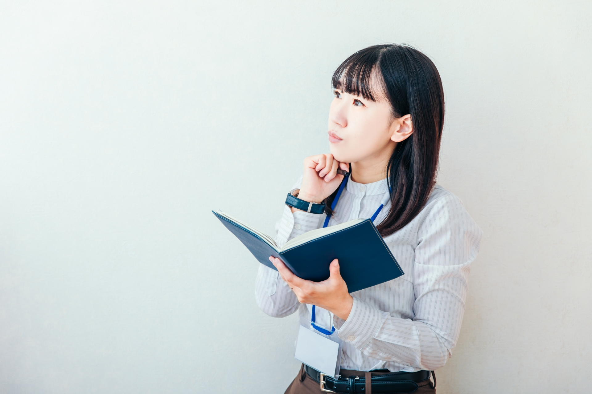 手帳を持って悩む女性