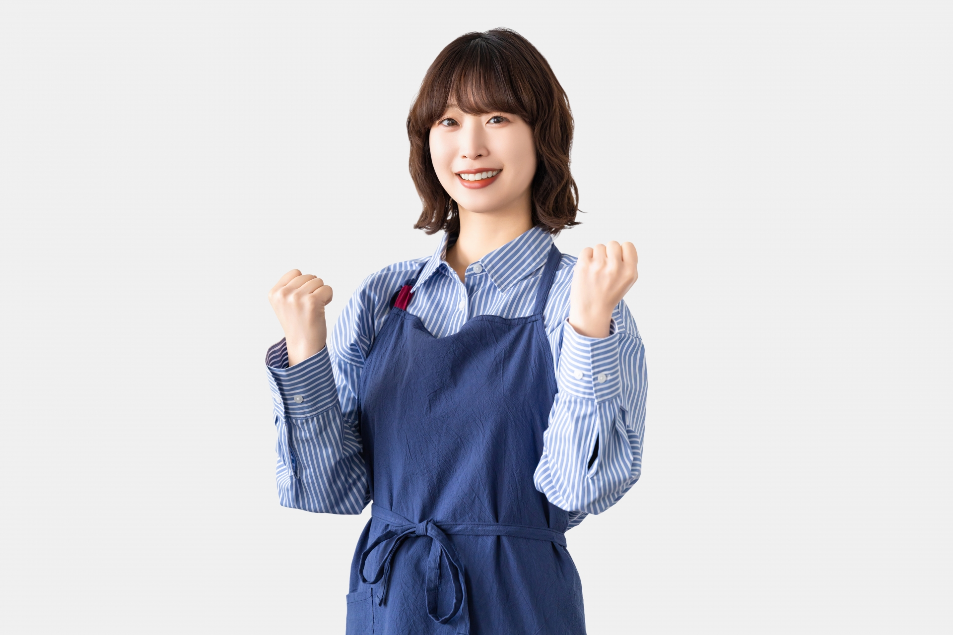 ガッツポーズをするエプロン姿の女性