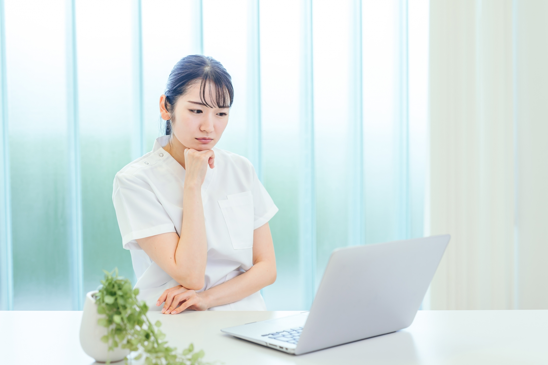PCを見ながら悩む女性