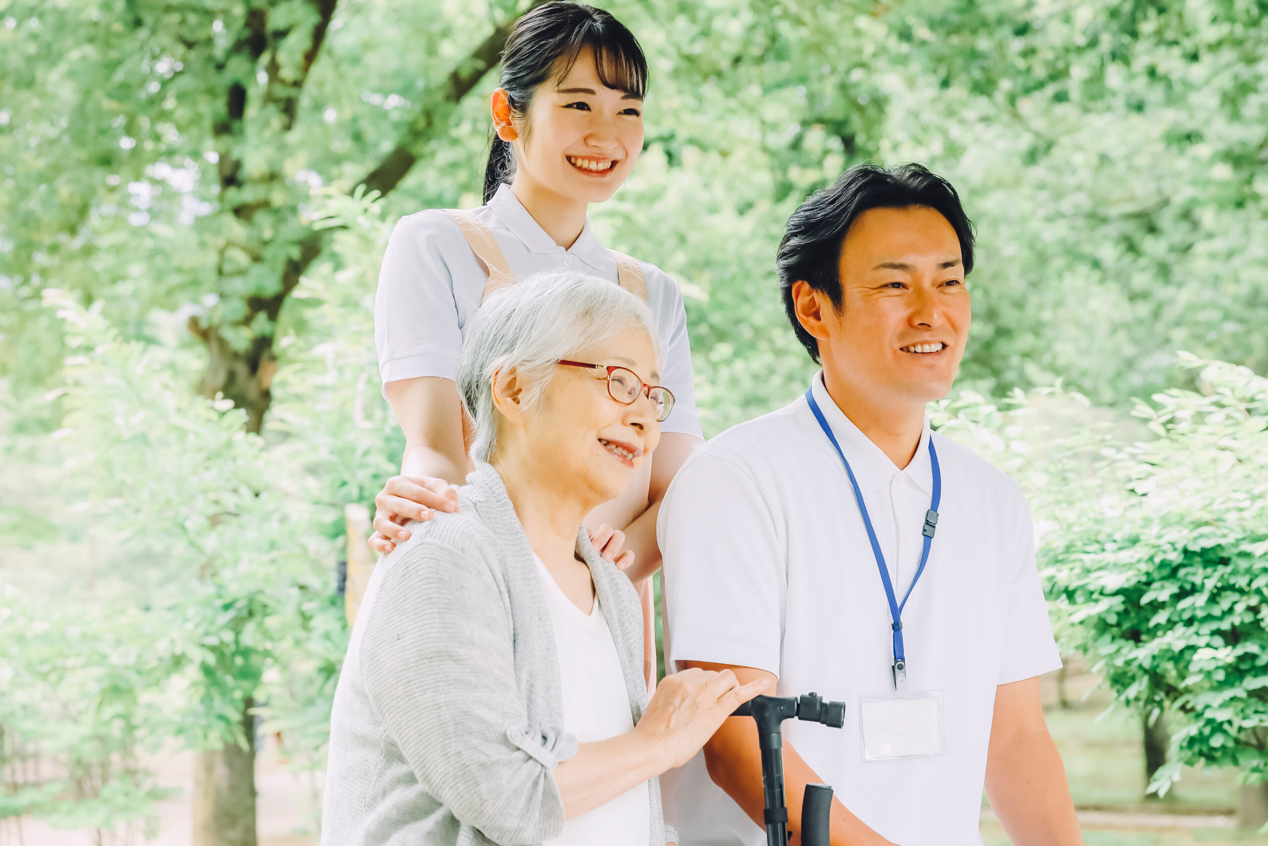 高齢者女性と男女スタッフ