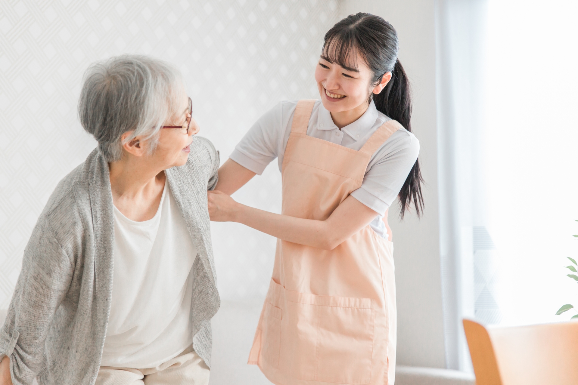 訪問介護する女性と高齢者（笑顔）