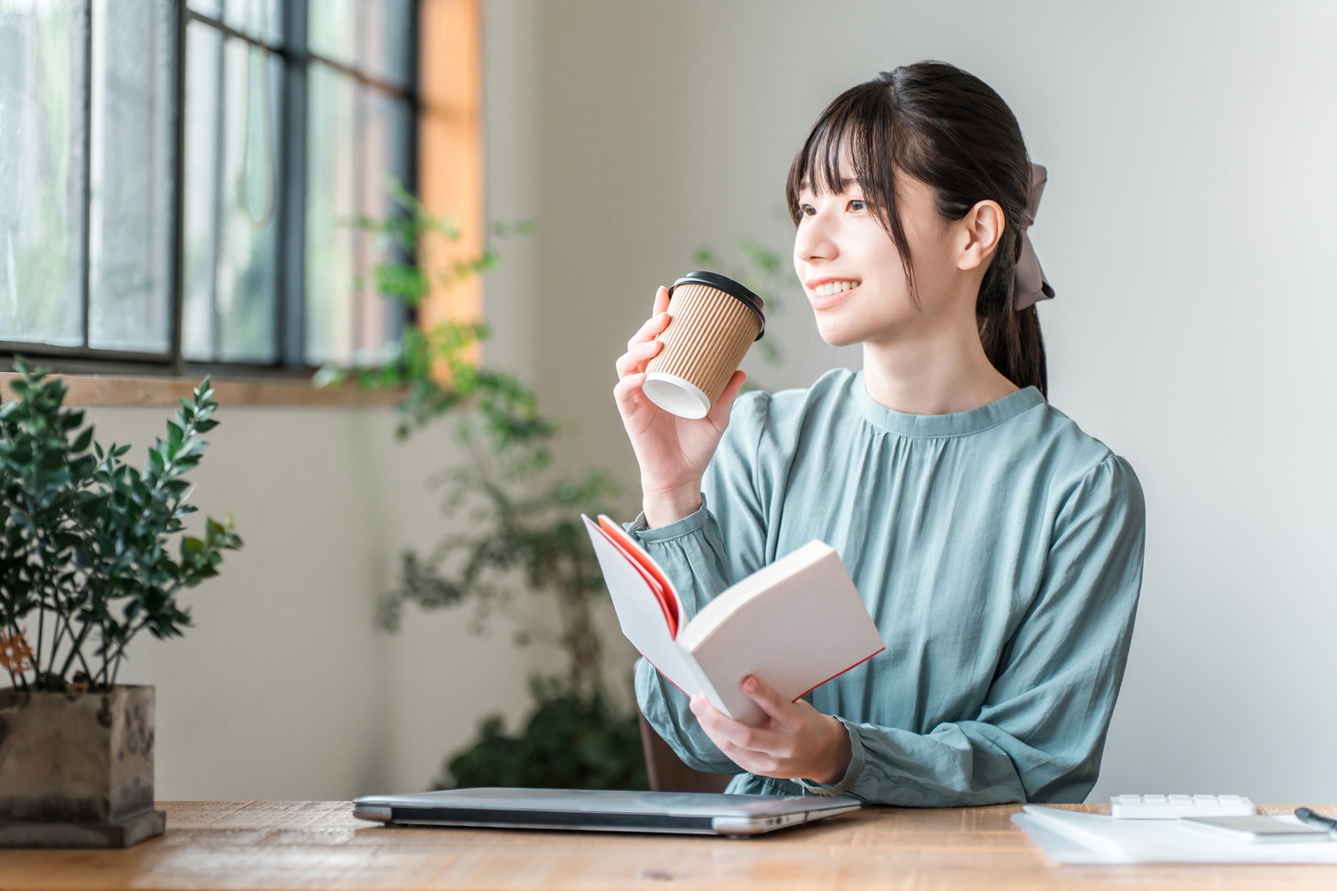 カフェで読書する若い女性（自己啓発）