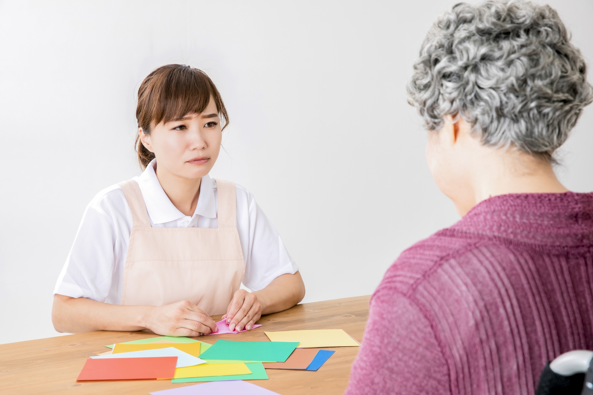 悲しい話をする高齢者の女性と介護士