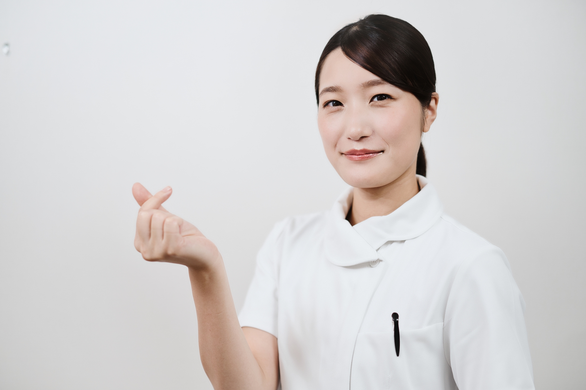 指ハートする女性