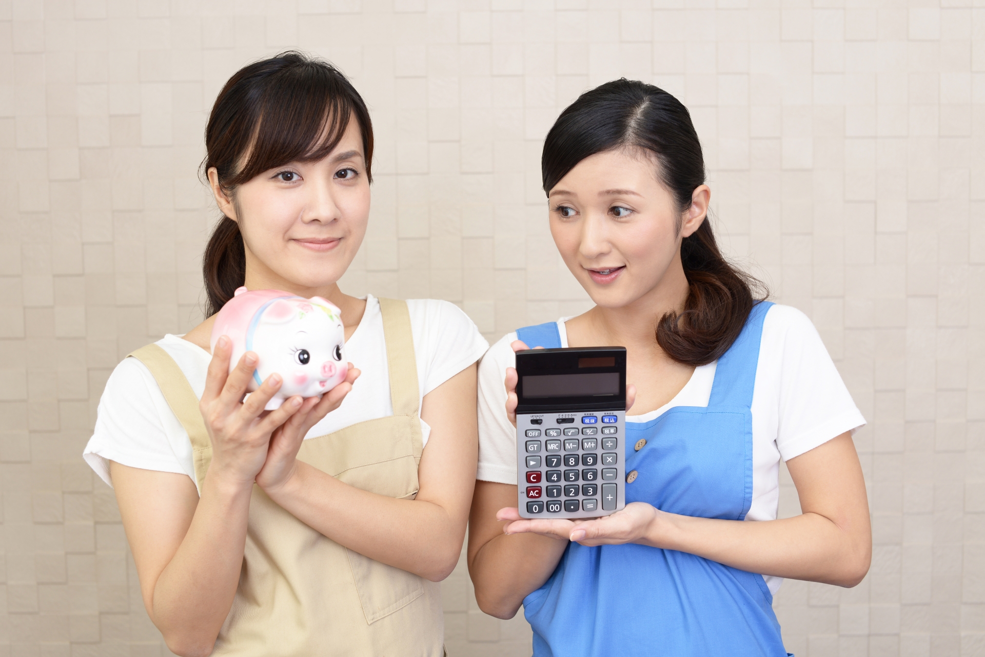 豚の貯金箱と計算機を持つ二人の女性