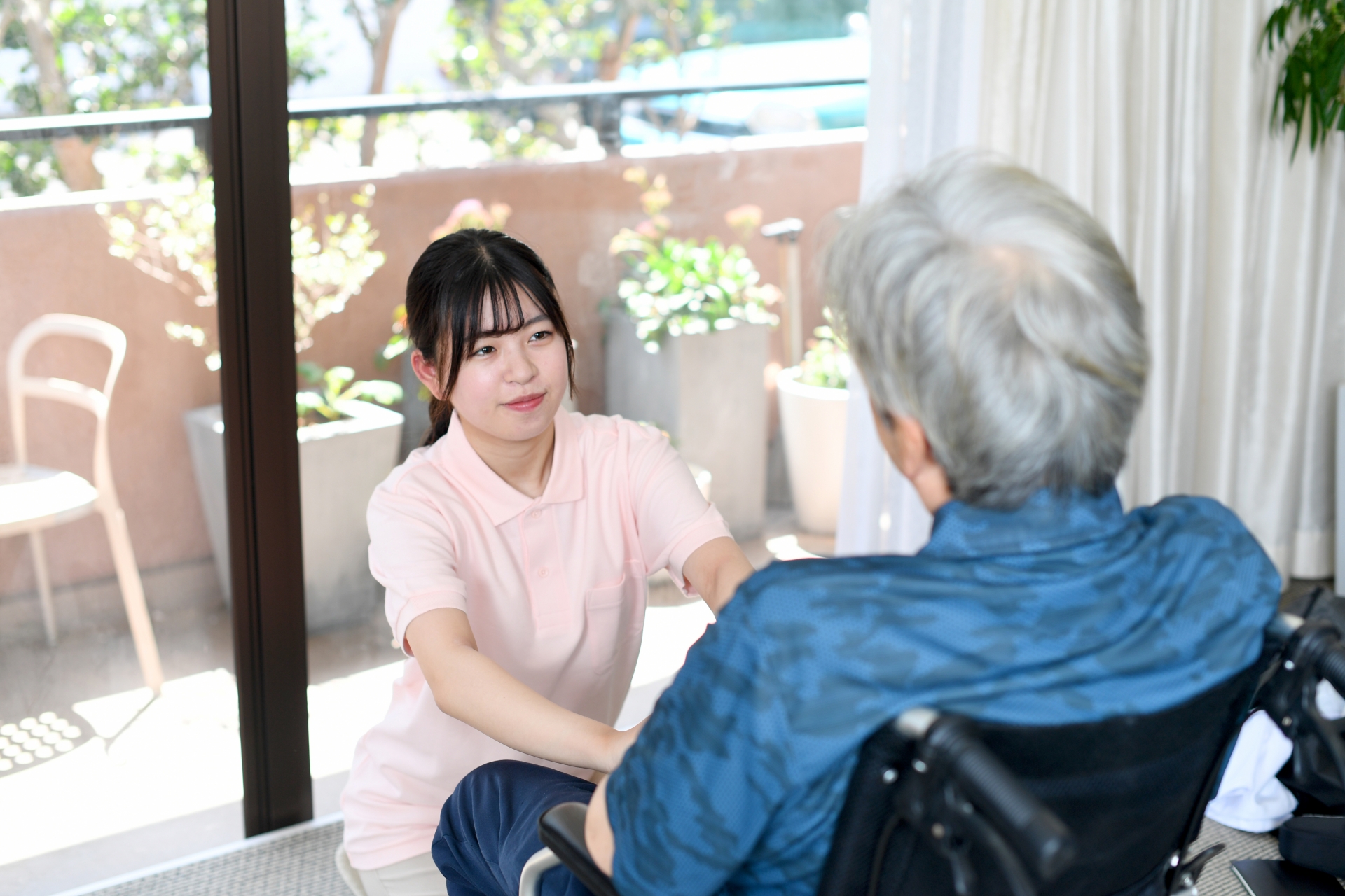 車椅子に乗る高齢者と女性の介護士