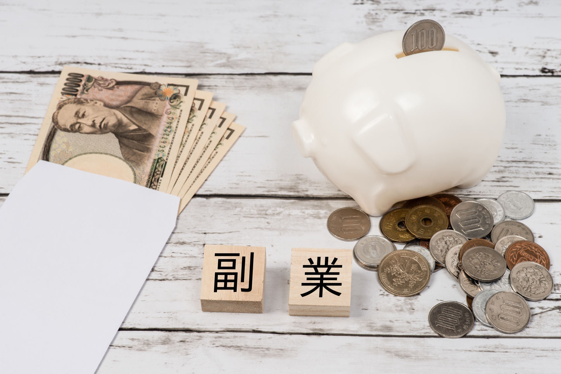 現金とぶたの貯金箱で副業のイメージ