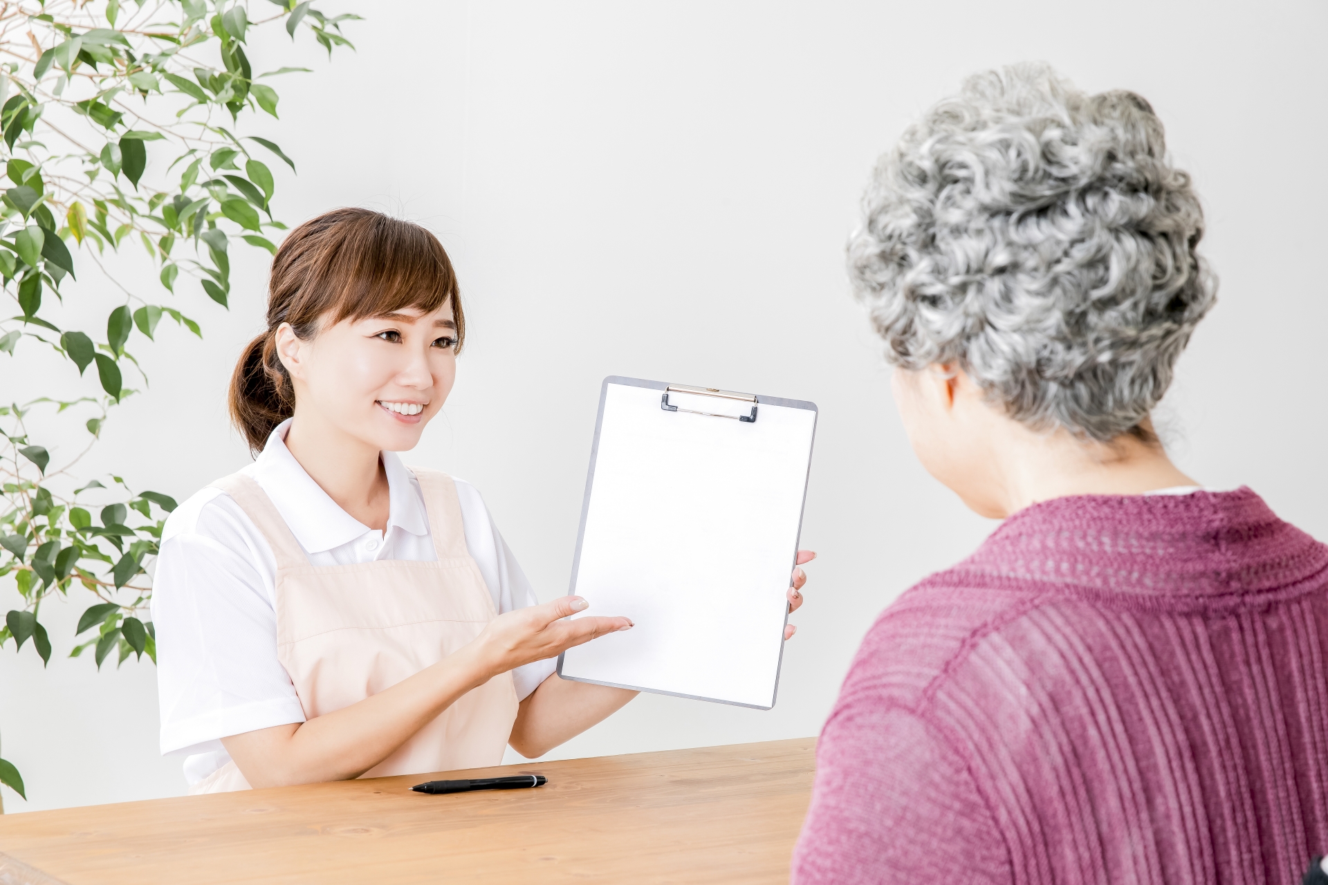 説明する介護士と高齢者の女性