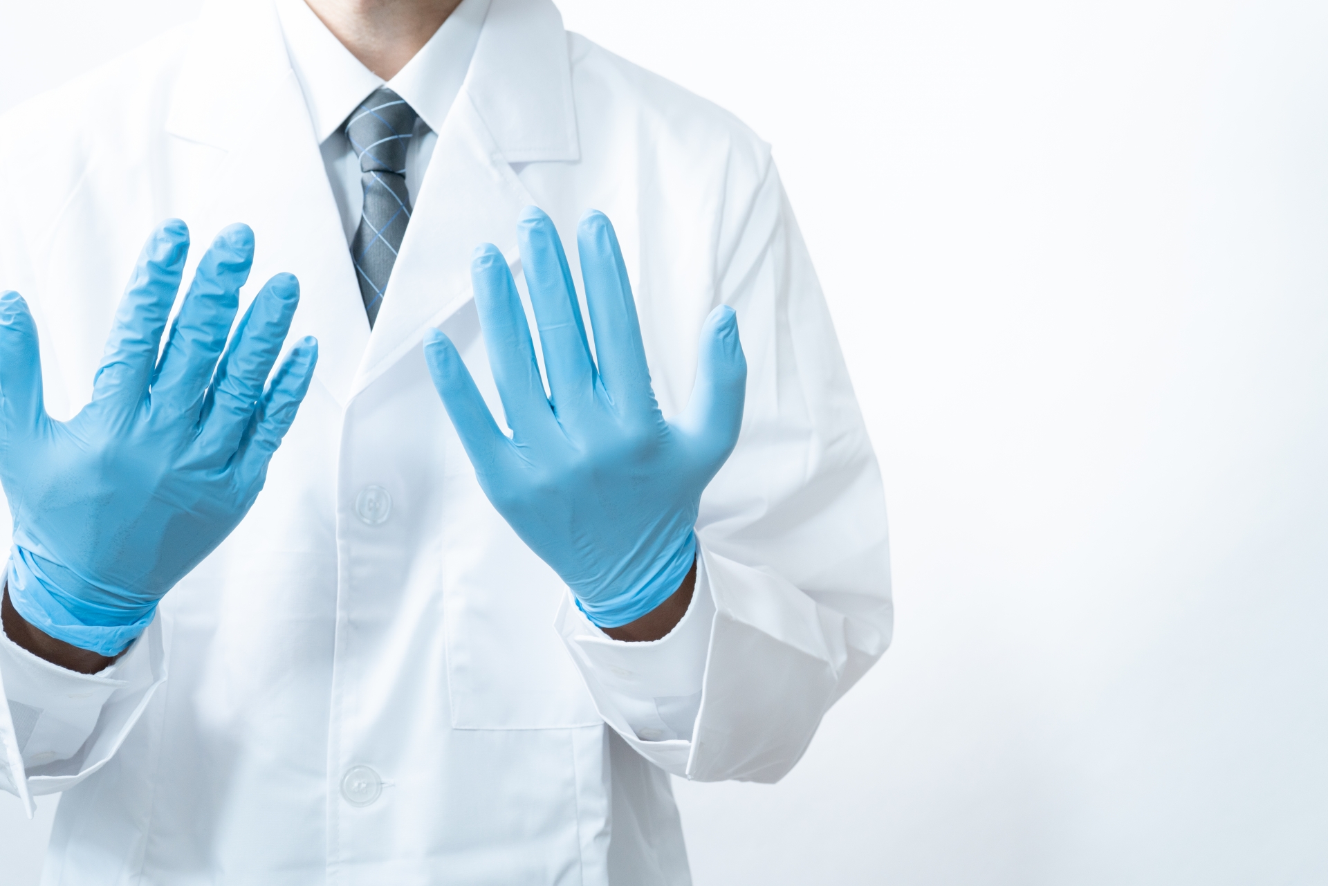 医療用手袋をした男性医師が治療をするイメージ
