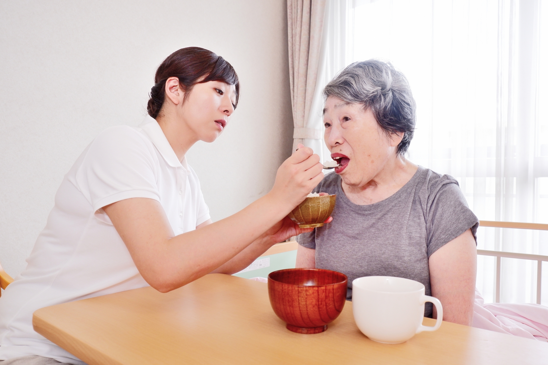 おばあちゃんにご飯を食べさせる介護士4