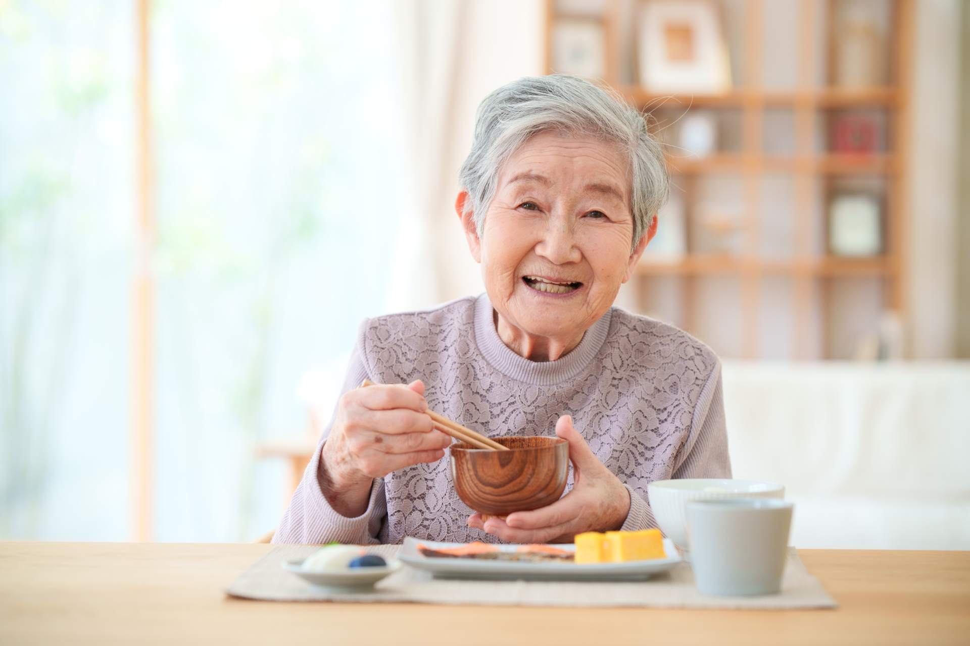 お椀を持ちカメラ目線の女性