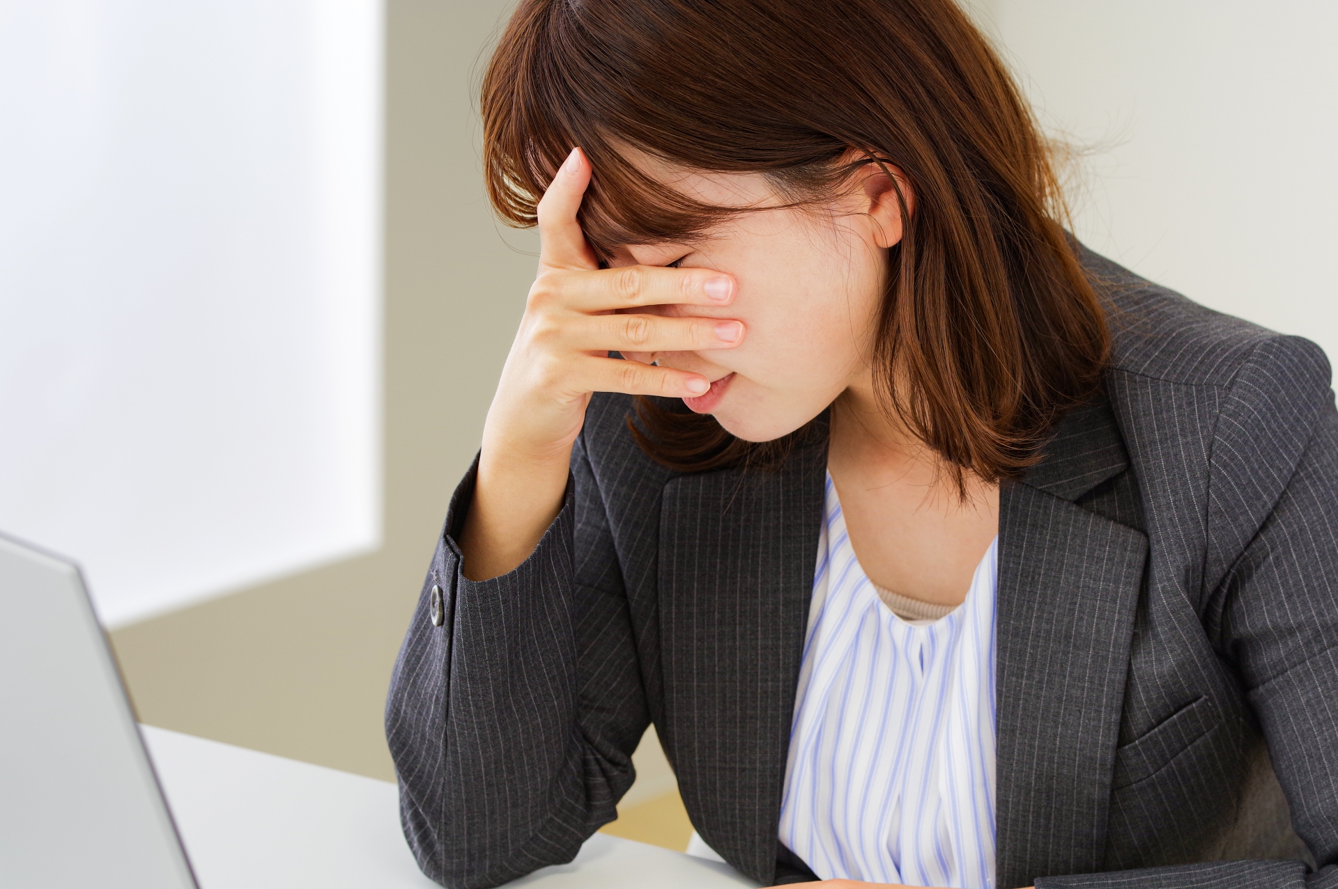 疲労が溜まってつらそうな女性社員