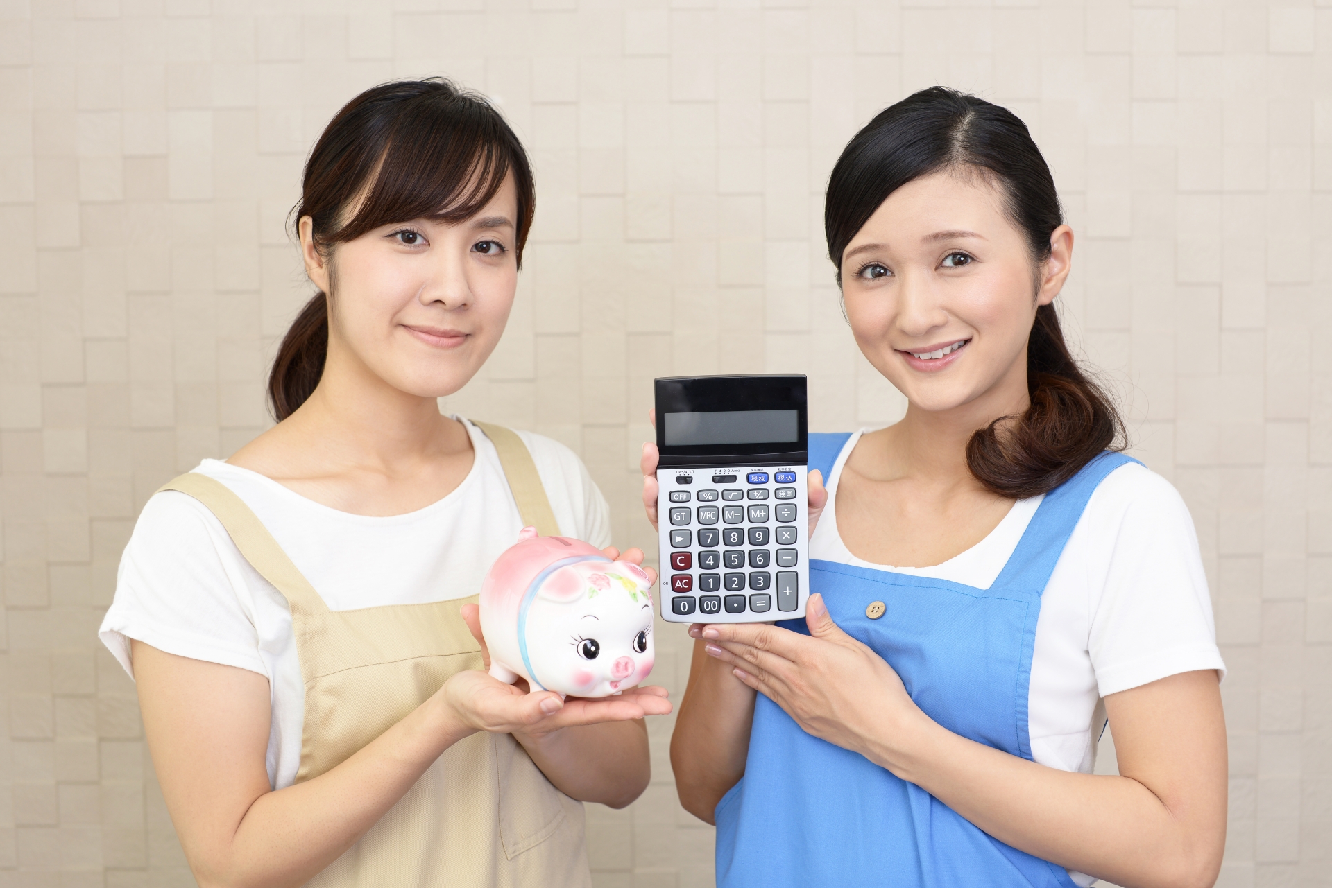 豚の貯金箱と計算機を持つ二人の女性