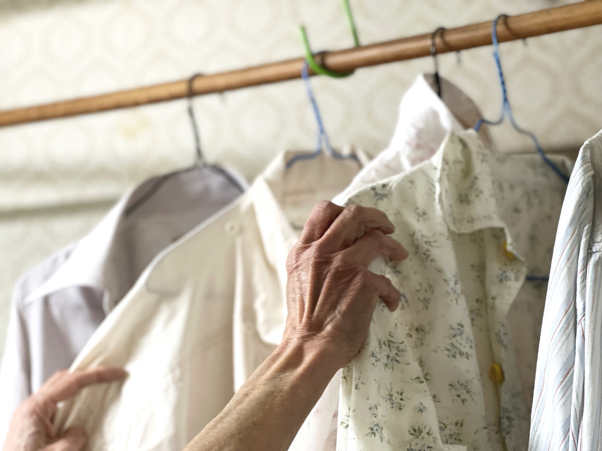 洋服を選ぶ高齢女性の手