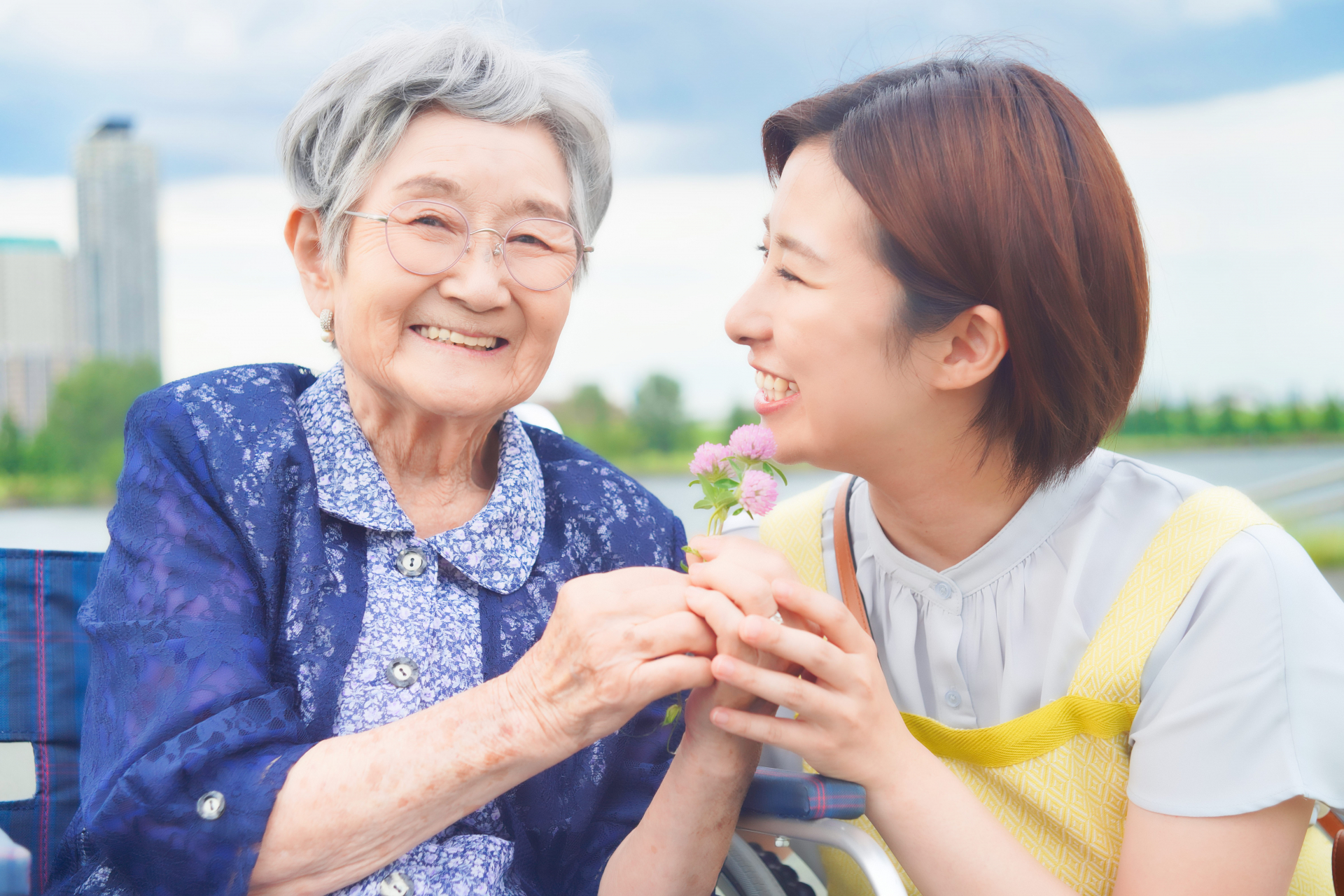 手を握って記念撮影をする高齢者とヘルパー