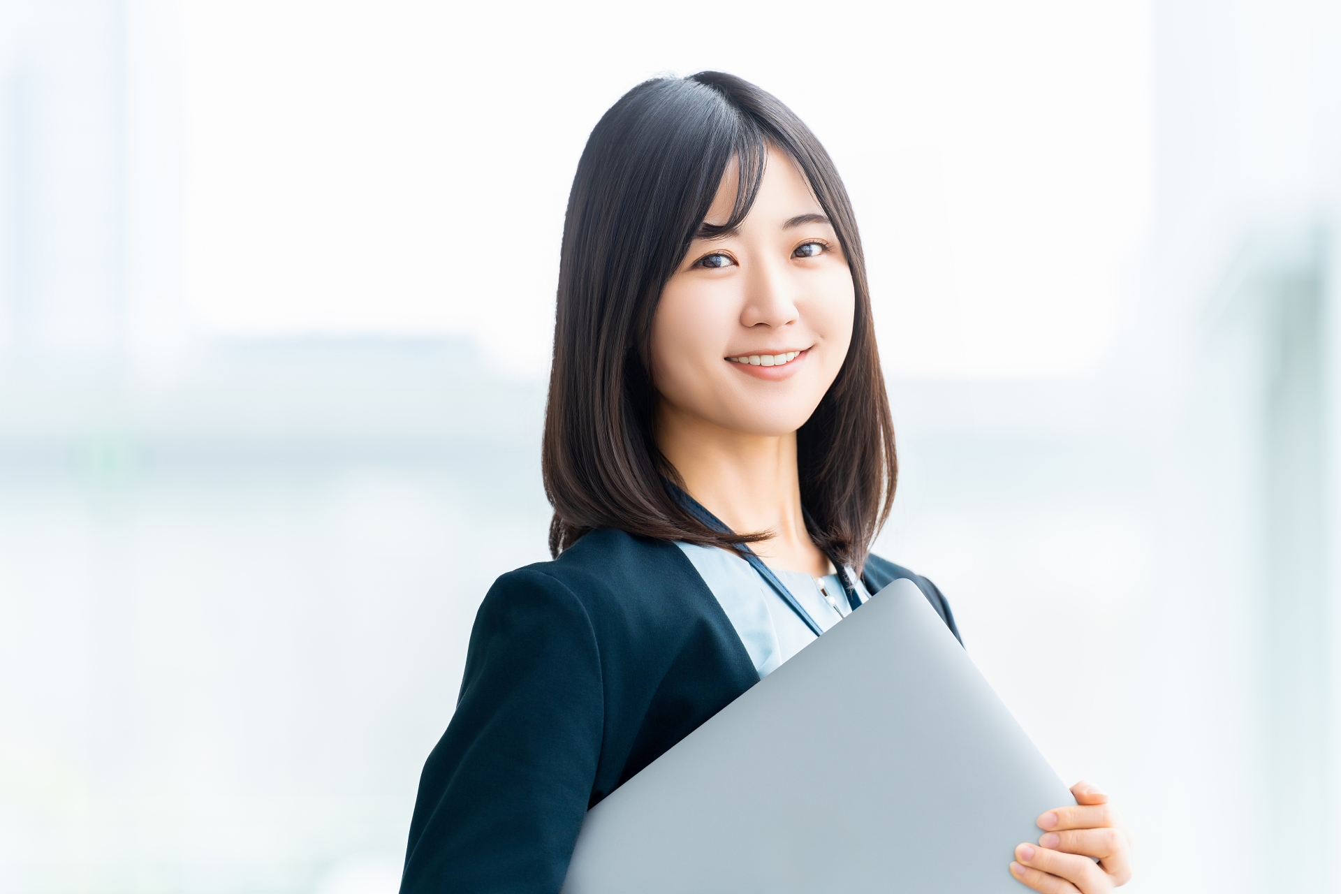 ノートパソコンを抱える女性