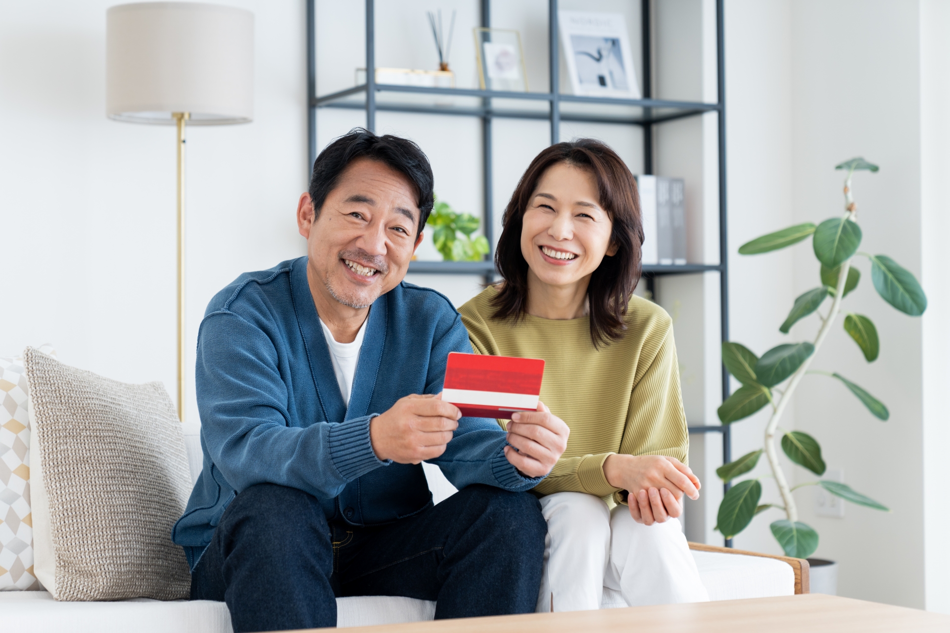 通帳を見てほほ笑む夫婦