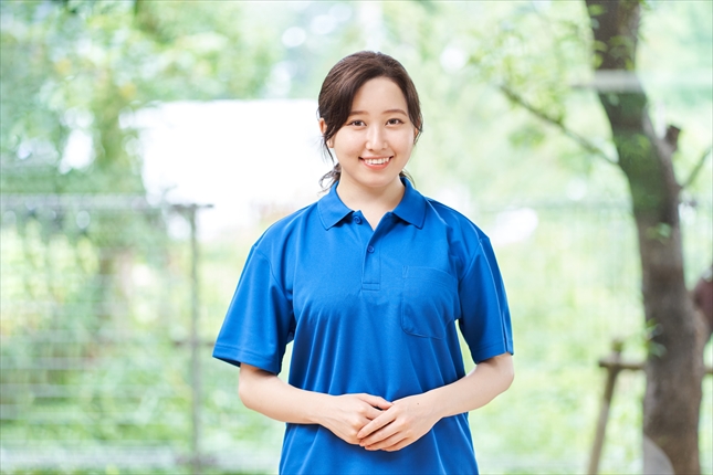 緑背景で立つ女性介護士