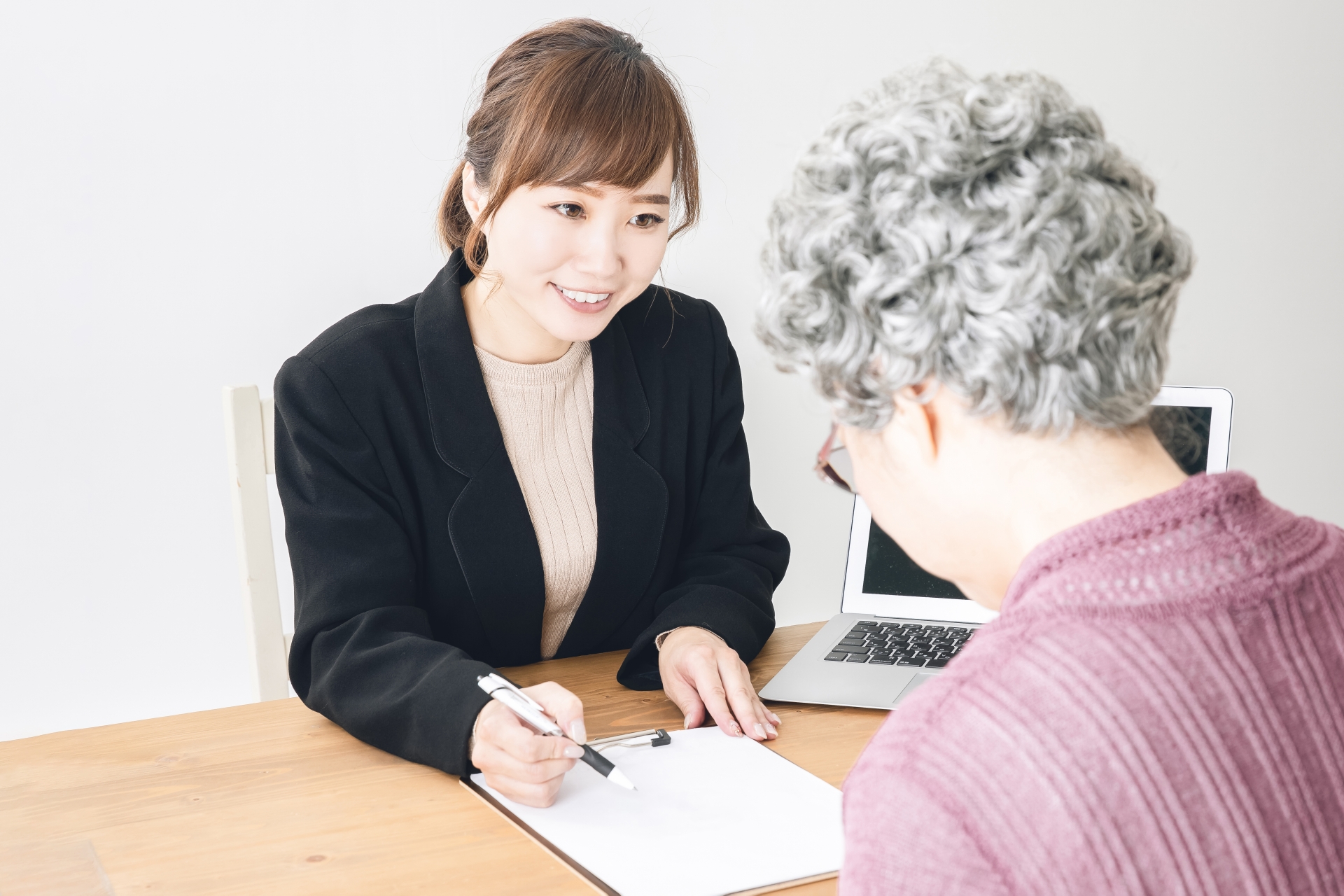 スーツ姿の女性と高齢者