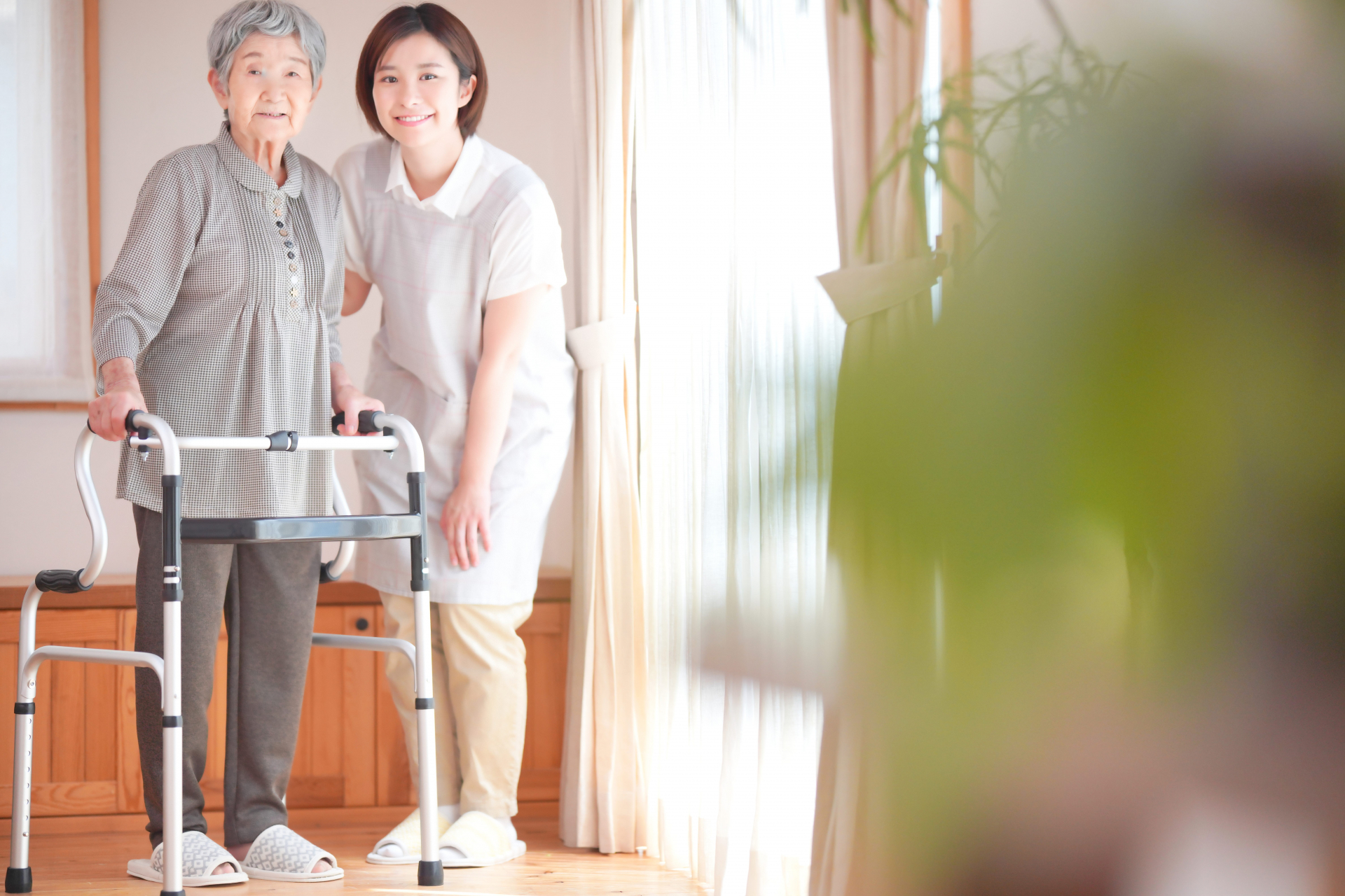 高齢者が立つのを手伝うヘルパー