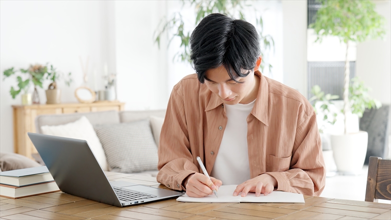 ノートに書き込む男性