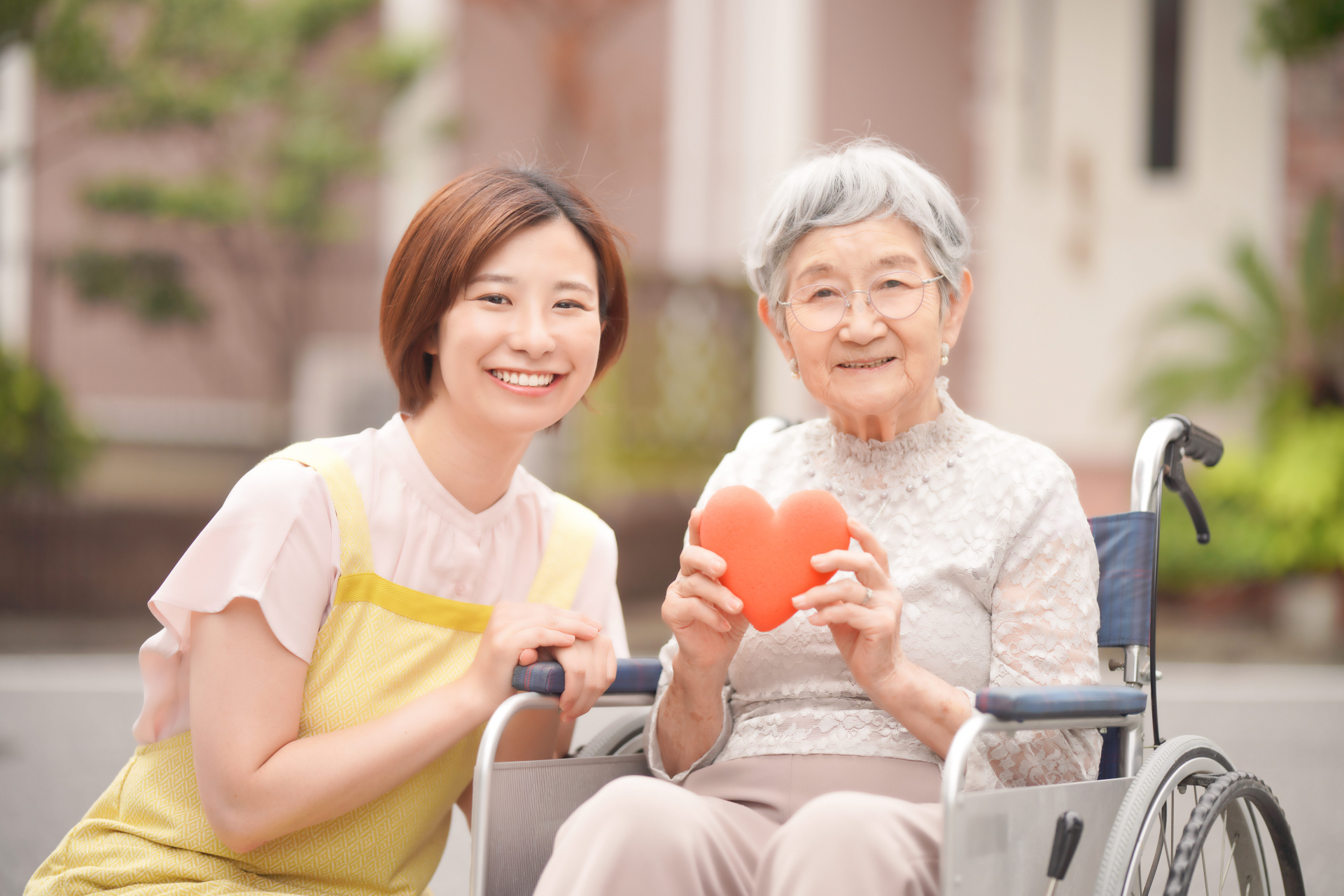 ハートの模型をもらう高齢者とヘルパー