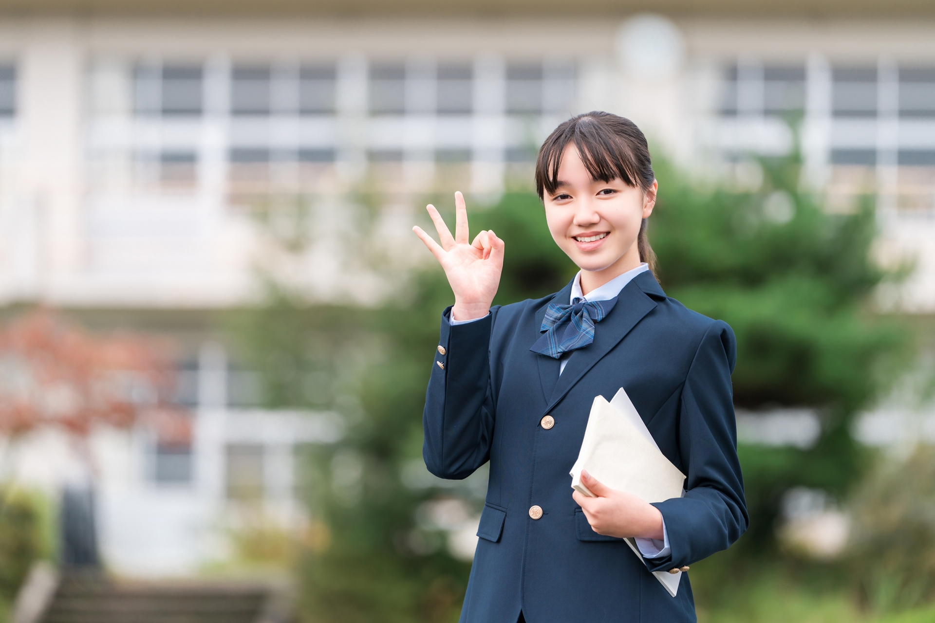 学校の校舎の前に立つ中学生