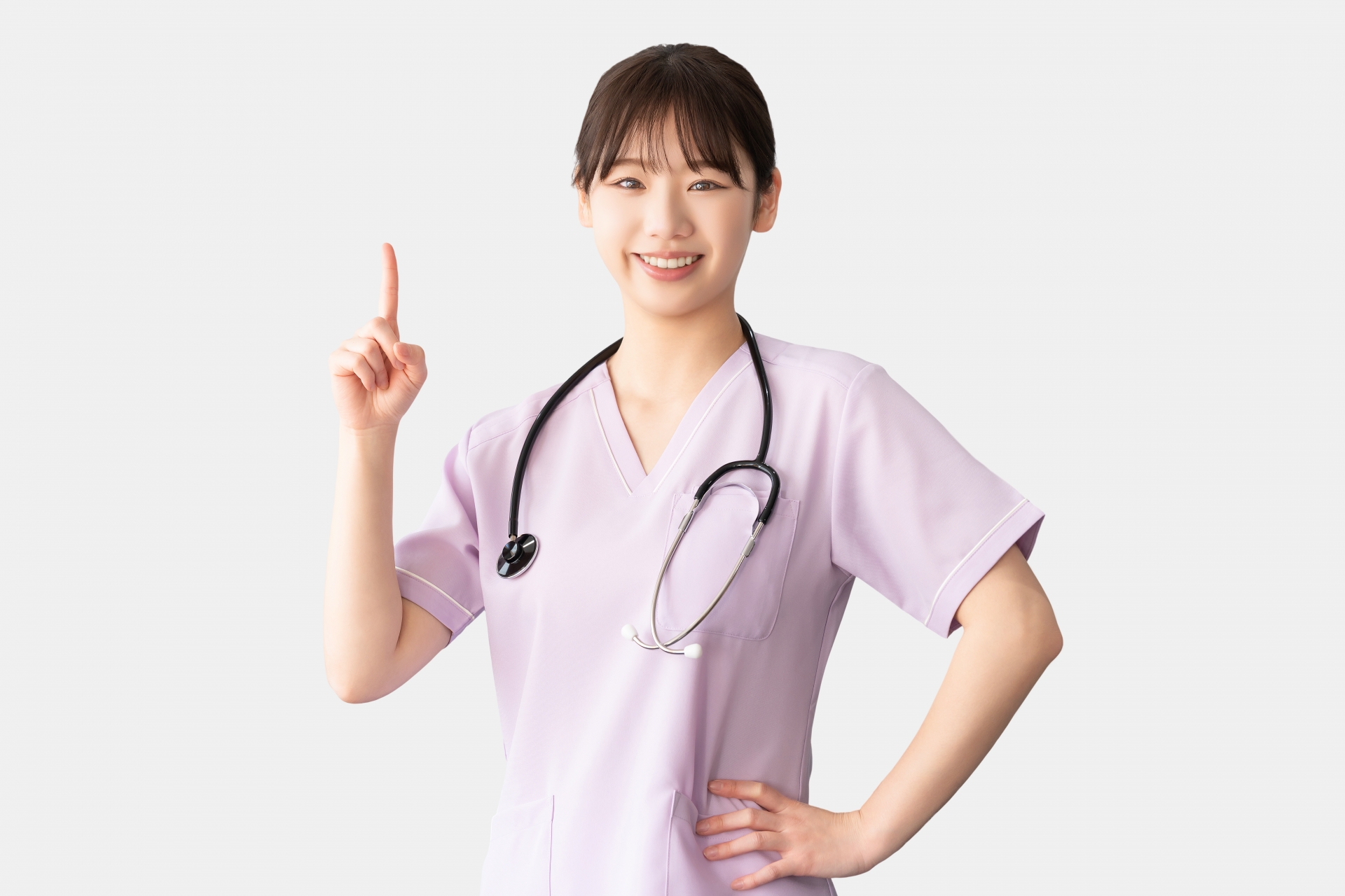 人差し指を立てて案内する女性医療スタッフ