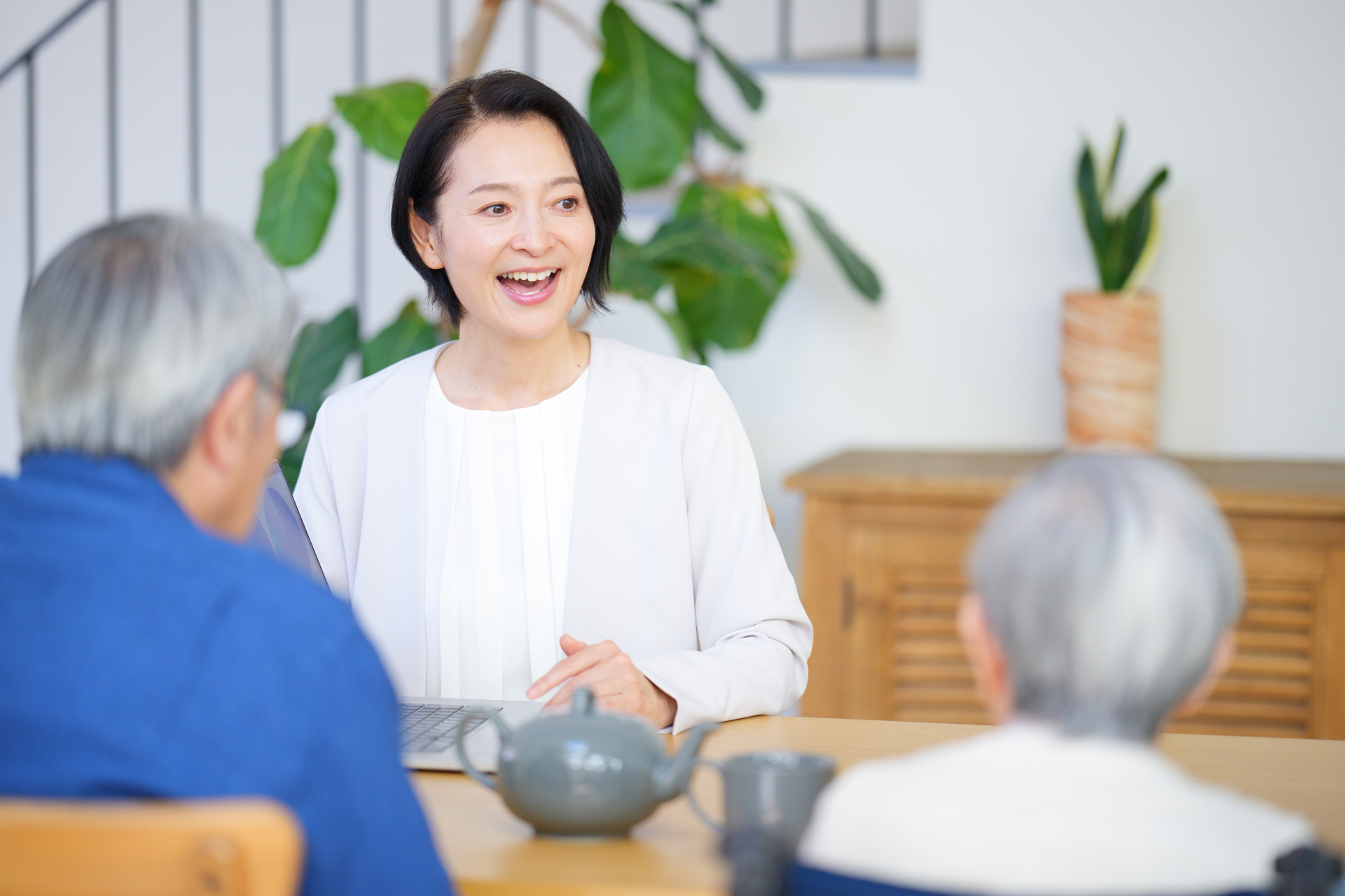高齢女性とその家族に説明するケアマネジャー