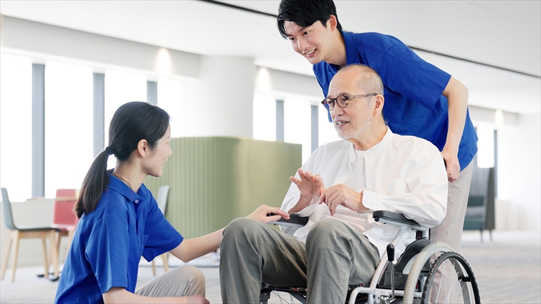 介護士と話をする車椅子の高齢者