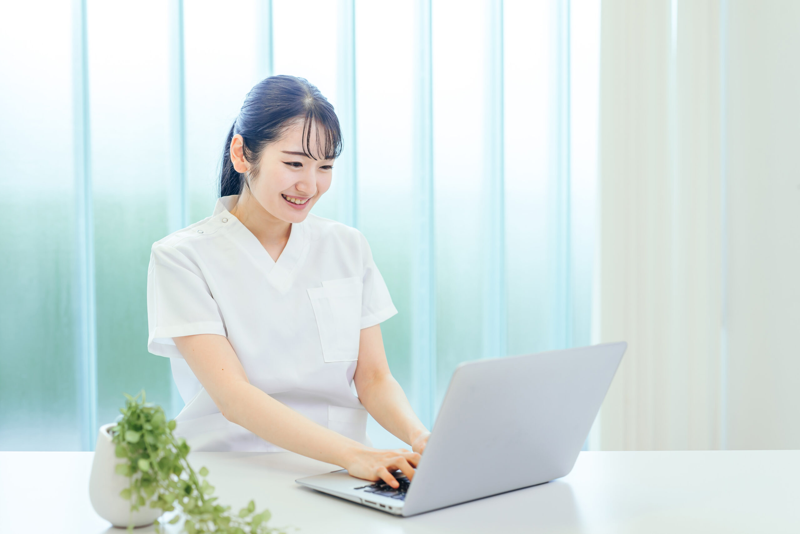 パソコンを使う白衣姿の女性