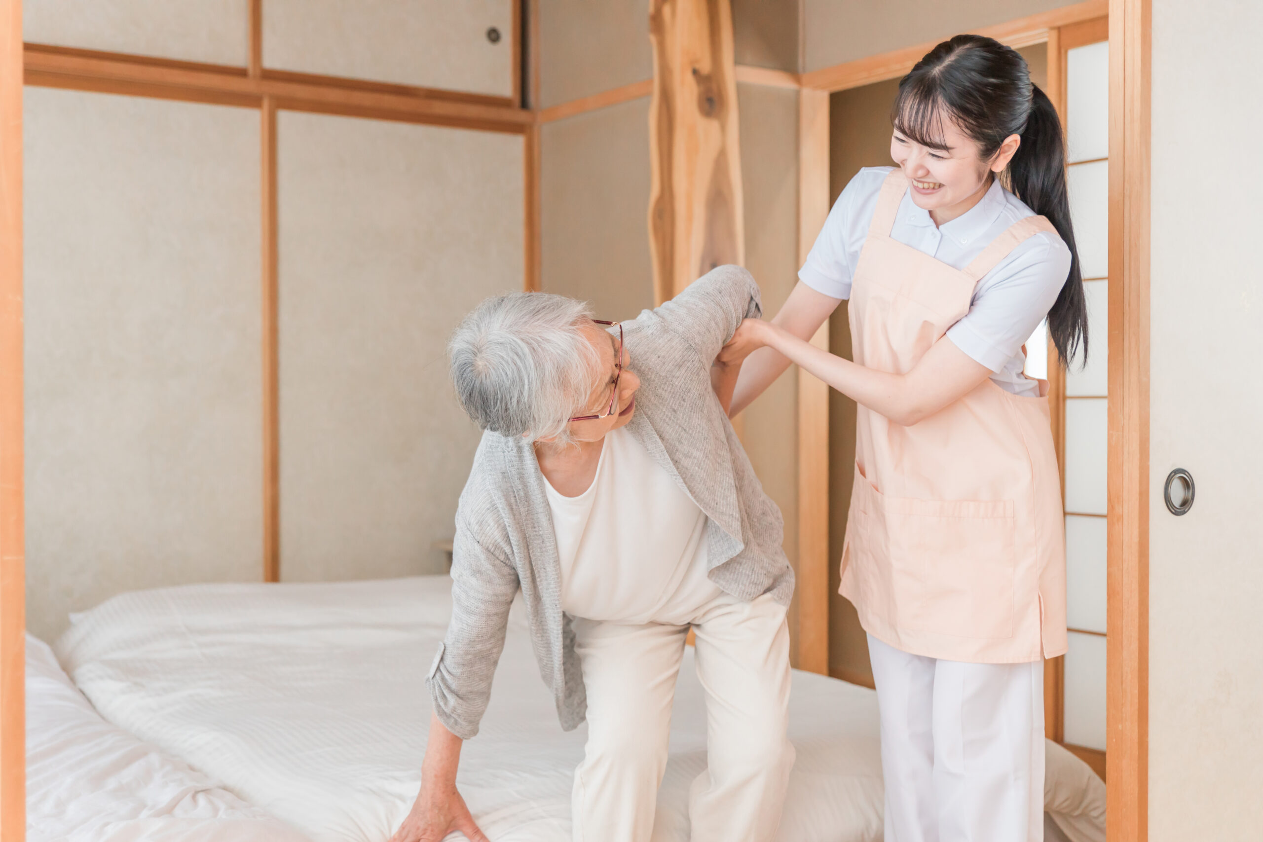 訪問介護する女性と高齢者