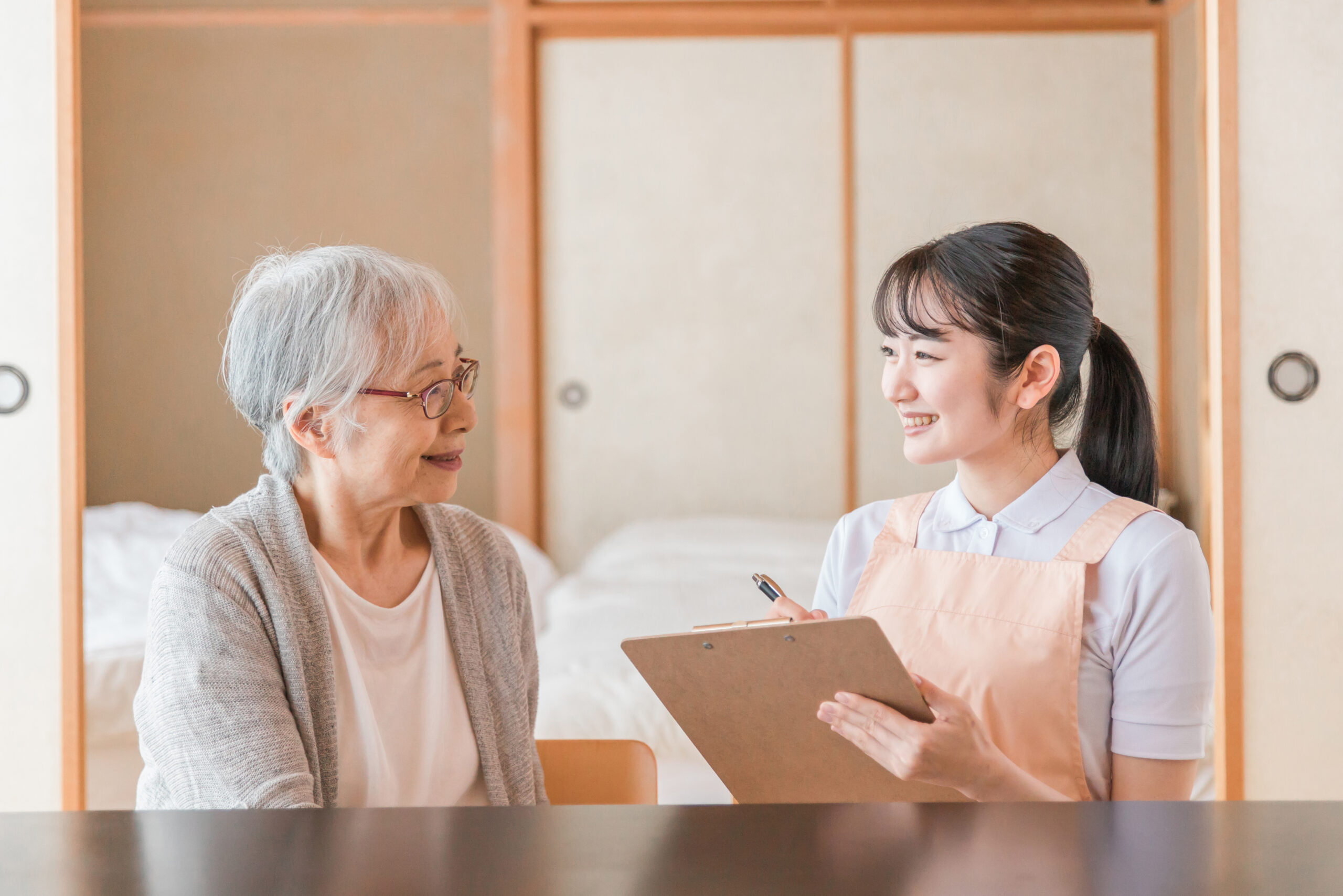 高齢者女性と話す女性スタッフ